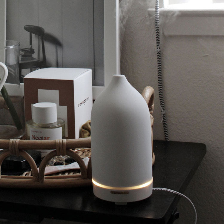 A white matte ceramic diffuser diffusing on a nightstand
