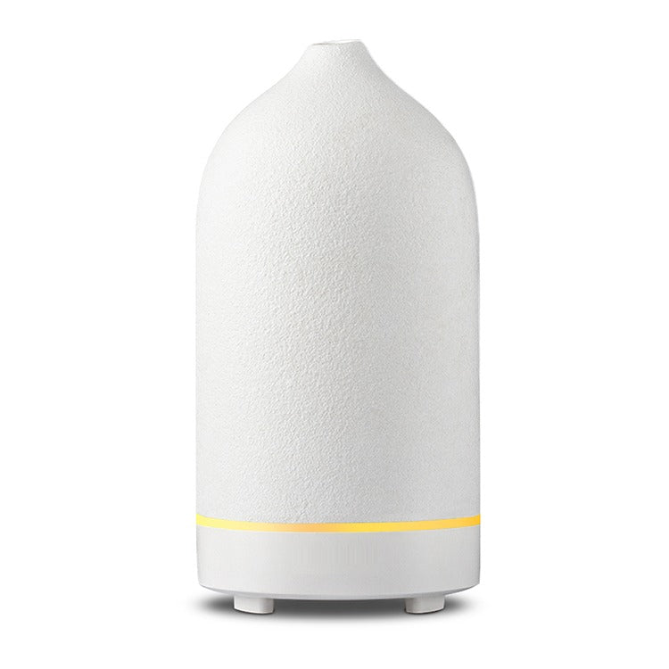 White matte ceramic diffuser with a ring of yellow light around the base